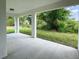 Covered patio with concrete flooring, offering a view of the backyard greenery at 481 S East Ave, Bartow, FL 33830