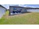 Spacious backyard with green lawn and a patio area featuring wicker furniture and a grill at 8830 Fox Dr, Polk City, FL 33868