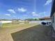 Expansive backyard overlooking a pond, featuring a patio with wicker furniture and green grass at 8830 Fox Dr, Polk City, FL 33868