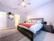 This bedroom features neutral walls, an ensuite bathroom and a ceiling fan at 8830 Fox Dr, Polk City, FL 33868