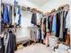 Walk-in closet with metal shelving, hanging clothes and a bench at 8830 Fox Dr, Polk City, FL 33868