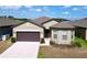 Beautiful single-Gathering home featuring a two-car garage, manicured landscaping, and a welcoming entrance at 8830 Fox Dr, Polk City, FL 33868