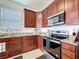 Kitchen showcases stainless steel appliances, granite countertops, and abundant wood cabinets at 8830 Fox Dr, Polk City, FL 33868