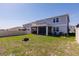 Large backyard with green grass, potted plants, and a covered, screened-in patio area at 1123 Sugarwood St, Davenport, FL 33837