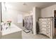 Bright bathroom featuring a double sink vanity, shower, and a decorative dresser at 1123 Sugarwood St, Davenport, FL 33837