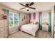 Charming bedroom with a ceiling fan, pastel striped walls, and a view of the neighborhood at 1123 Sugarwood St, Davenport, FL 33837
