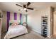 Comfortable bedroom with a ceiling fan, striped wall decor, and organized shoe rack at 1123 Sugarwood St, Davenport, FL 33837