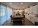 Open dining area with a view of the kitchen, lots of cabinetry, and a large sliding glass door at 1123 Sugarwood St, Davenport, FL 33837