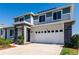 Attractive two-story home with stone accents, a two-car garage, and lush green landscaping on a bright day at 1123 Sugarwood St, Davenport, FL 33837