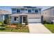 Inviting two-story home with a manicured lawn, stone accents, and attached two-car garage at 1123 Sugarwood St, Davenport, FL 33837