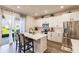 This open kitchen features an island with seating, stainless appliances, and backyard access at 1123 Sugarwood St, Davenport, FL 33837