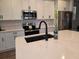 Up-close shot of a kitchen island with quartz countertops, stainless steel appliances, and a modern faucet at 1123 Sugarwood St, Davenport, FL 33837