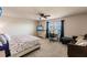 Spacious main bedroom with a ceiling fan, TV, desk, and comfortable seating area at 1123 Sugarwood St, Davenport, FL 33837
