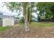Backyard featuring a shed, mature trees, and a partial wooden fence surrounding the property at 5926 N Fork Ct, Lakeland, FL 33809