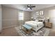 Bedroom featuring a neutral palette, ceiling fan, bench, and decorative lamps on matching bedside tables at 5926 N Fork Ct, Lakeland, FL 33809