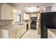 Functional kitchen featuring tiled countertops, black appliances, and ample cabinet space for storage at 5926 N Fork Ct, Lakeland, FL 33809