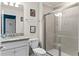Bathroom features a granite countertop, walk-in shower, and bright lighting, creating a clean and functional space at 7614 Oak Spring Ln, Davenport, FL 33837