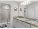 Bathroom featuring double sink with granite countertop, and shower with glass door at 7614 Oak Spring Ln, Davenport, FL 33837