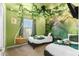 Whimsical green bedroom featuring hanging plants, a tree mural, and a unique swing, creating an enchanting atmosphere at 7614 Oak Spring Ln, Davenport, FL 33837