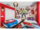 The bedroom features vibrant red walls and playful Marvel superhero decor creating a fun and lively atmosphere at 7614 Oak Spring Ln, Davenport, FL 33837