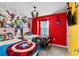 Bright bedroom featuring vibrant red walls, playful superhero decor, and large windows for plenty of natural light at 7614 Oak Spring Ln, Davenport, FL 33837