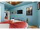 Comfortable bedroom with blue walls, drop ceiling, and Harry Potter themed decorations and TV at 7614 Oak Spring Ln, Davenport, FL 33837
