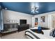 Spacious bedroom featuring crib, television, and full bathroom at 7614 Oak Spring Ln, Davenport, FL 33837
