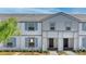 Charming townhome with neutral paint, blue shutters, and a well-kept lawn at 7614 Oak Spring Ln, Davenport, FL 33837