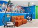 Game room featuring colorful mural wall, hanging chairs, and comfortable seating at 7614 Oak Spring Ln, Davenport, FL 33837