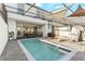 Inviting pool area featuring a screened lanai, lounge chairs, and a dining area, perfect for enjoying the outdoors at 7614 Oak Spring Ln, Davenport, FL 33837