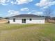 Backyard with white siding, a black shingle roof, and a grassy lawn at 2680 Sw 144 Ct, Ocala, FL 34481