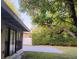 A spacious backyard with a concrete patio, mature trees, and a privacy fence at 2818 Dellwood Dr, Orlando, FL 32806