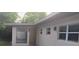 Front exterior featuring new windows, a charming entry door, and updated exterior lights at 2818 Dellwood Dr, Orlando, FL 32806