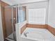 Bright bathroom featuring a glass-enclosed shower and a soaking tub with stylish brown tile accents at 3125 Kearns Rd, Mulberry, FL 33860