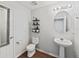 Updated half bathroom with a modern toilet, vanity, and decorative wall shelves at 3125 Kearns Rd, Mulberry, FL 33860