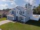 Blue two-story home boasts an expansive lawn and solar panels on its roof at 3125 Kearns Rd, Mulberry, FL 33860