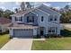 Charming blue two-story home with well-manicured lawn and attached two-car garage at 3125 Kearns Rd, Mulberry, FL 33860