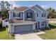 Two-story blue home with a spacious front yard and attached two-car garage at 3125 Kearns Rd, Mulberry, FL 33860