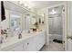 Bathroom featuring white vanity with dual sinks, large mirrors and access to the shower and tub at 4836 Pebble Beach Dr, Orlando, FL 32811