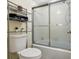 Bathroom featuring a glass enclosed shower, toilet, and a storage shelf with towels at 4836 Pebble Beach Dr, Orlando, FL 32811