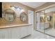 Bathroom featuring dual sinks, decorative mirrors, and a separate water closet at 4836 Pebble Beach Dr, Orlando, FL 32811