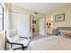 Cozy bedroom featuring neutral paint, carpet, white chair, and a view into the ensuite bathroom at 4836 Pebble Beach Dr, Orlando, FL 32811