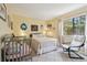 Bright bedroom with a daybed, chair, and ample natural light from the large window at 4836 Pebble Beach Dr, Orlando, FL 32811