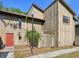 Two-story townhome featuring a neutral exterior, a vibrant red front door, and a well-maintained yard at 4836 Pebble Beach Dr, Orlando, FL 32811