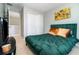 Bedroom showcasing a green upholstered bed, soft carpet, and a nearby closet with white doors at 6889 Wilson Hammock Ave, Groveland, FL 34736