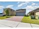 Inviting two-story home with a brick driveway and a spacious two-car garage at 6889 Wilson Hammock Ave, Groveland, FL 34736