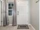 Bright entryway featuring a stylish front door, tiled floors, and elegant curtains at 6889 Wilson Hammock Ave, Groveland, FL 34736