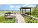Picturesque gazebo with seating on a wooden boardwalk, offering serene waterfront views and nature at 6889 Wilson Hammock Ave, Groveland, FL 34736