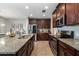 Spacious kitchen with granite counters, stainless steel appliances, and dark wood cabinetry at 6889 Wilson Hammock Ave, Groveland, FL 34736