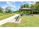 Scenic picnic area with covered tables, benches, and paved walkway surrounded by lush green landscaping at 6889 Wilson Hammock Ave, Groveland, FL 34736